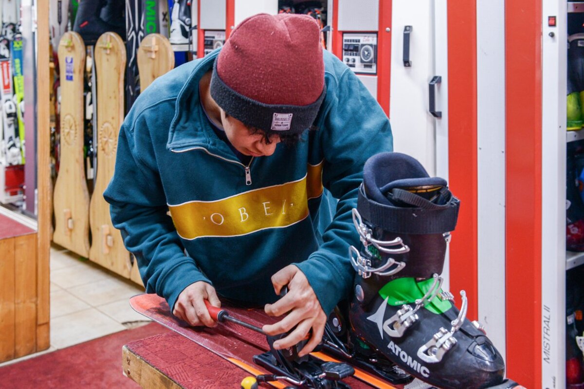 A man working on a pair of atomic ski boots