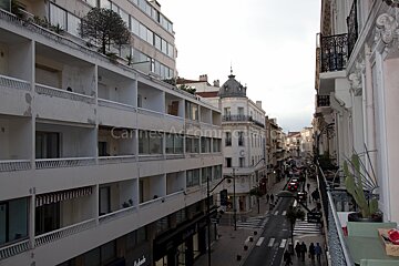 A view of a city street from a balcony that says cannes