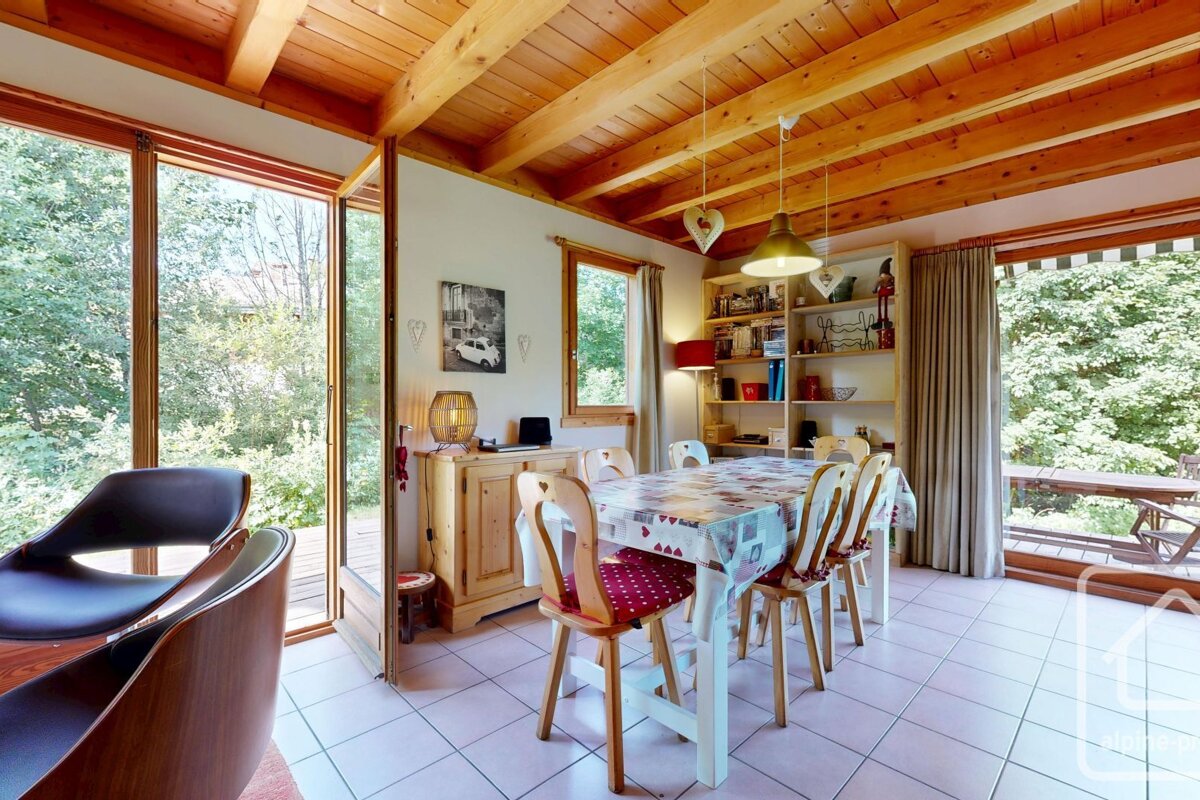 A dining room with a table and chairs and a picture of a car on the wall