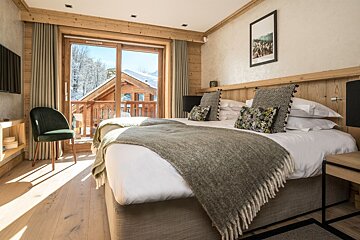 A hotel room with two beds and a balcony