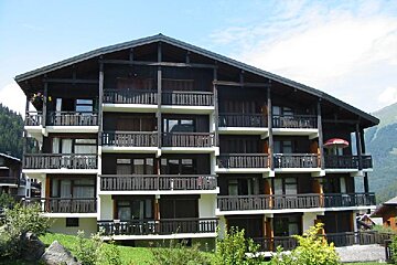 A large building with many balconies and a red umbrella