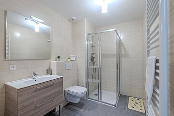 A bathroom with a toilet a sink and a shower