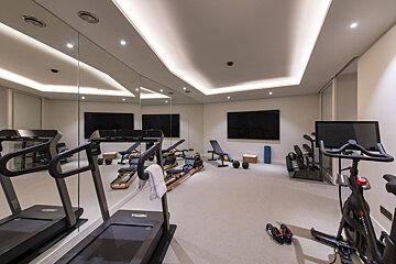 A gym with a treadmill that says technogym on it