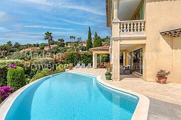 A large swimming pool in front of a house that says maisons provence immobilier