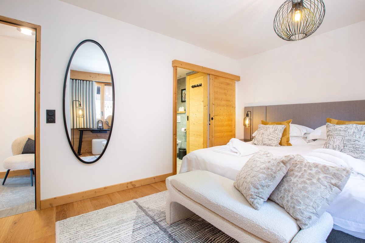 A bedroom with a large mirror on the wall