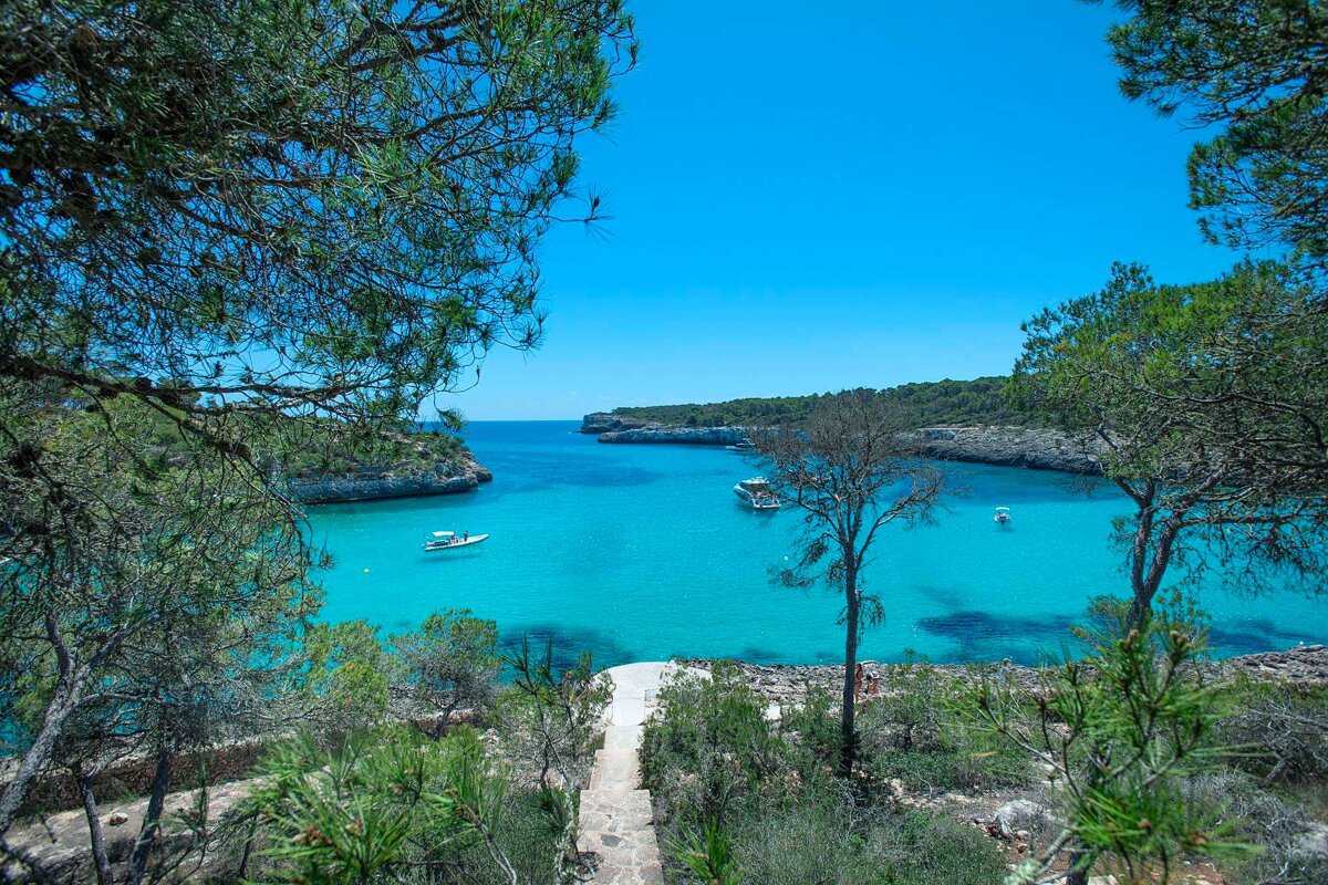 A few boats are floating in a turquoise bay