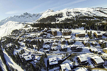 An aerial view of a ski resort with mountains in the background