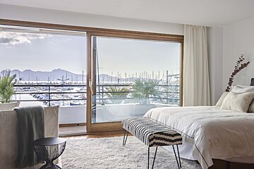 A bedroom with a sliding glass door leading to a balcony
