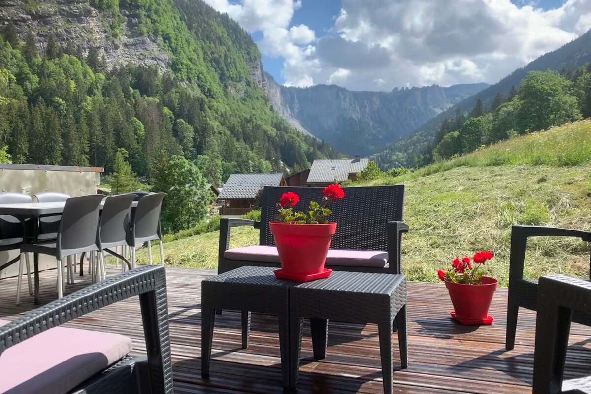 A patio with a view of mountains and trees