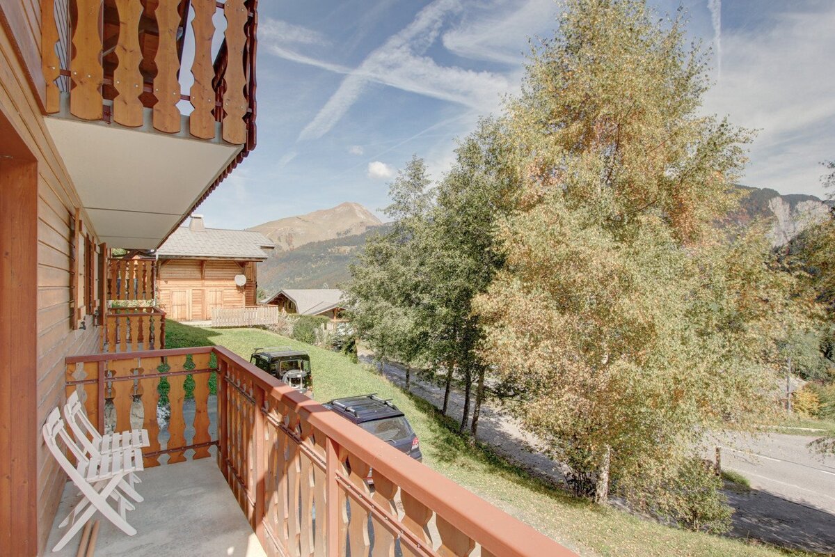 A balcony with a view of mountains and trees