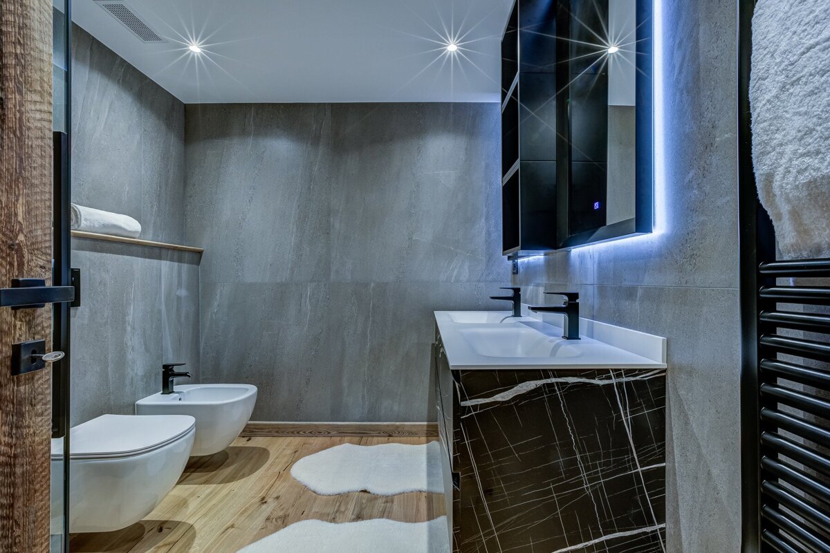 A bathroom with two sinks and a toilet