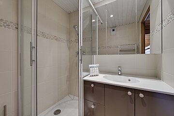 A bedroom with a bed and a wooden cabinet