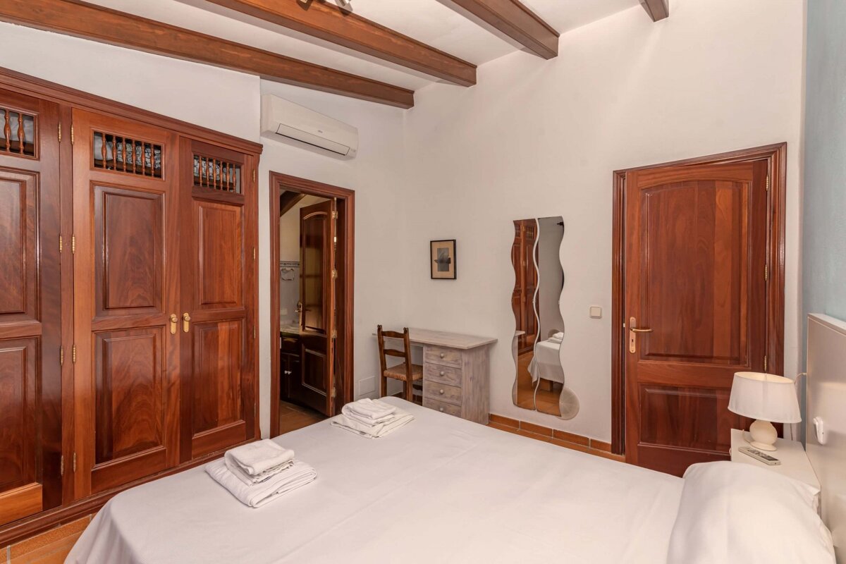 A bedroom with a large bed and a mirror