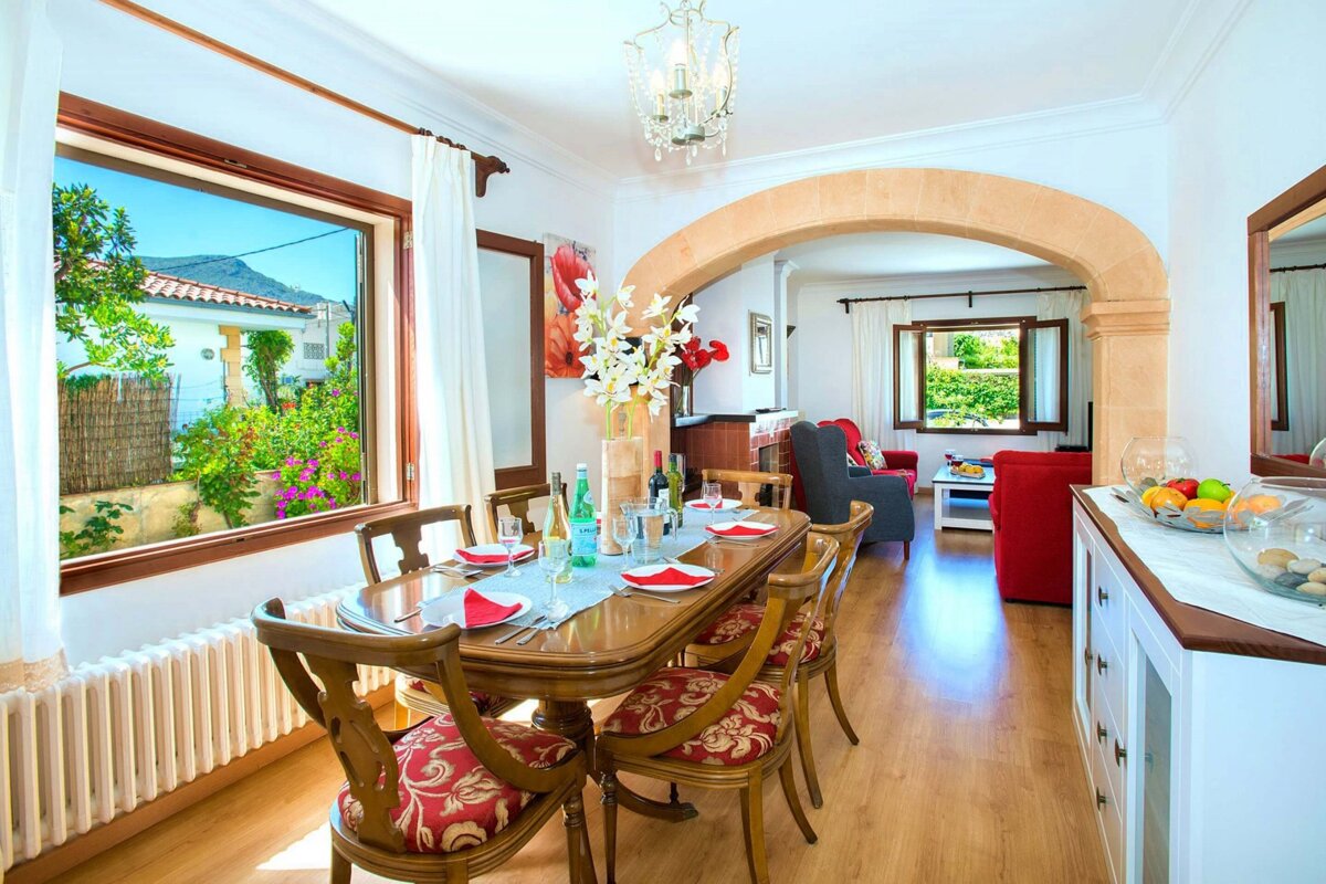 A dining room with a table and chairs and a window