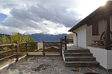 Stairs leading up to a balcony with mountains in the background