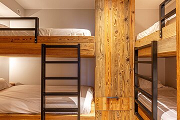 A bunk bed with a ladder in the middle of it