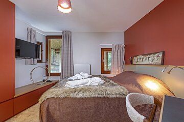 A bedroom with a bed and a picture of skiers on the wall