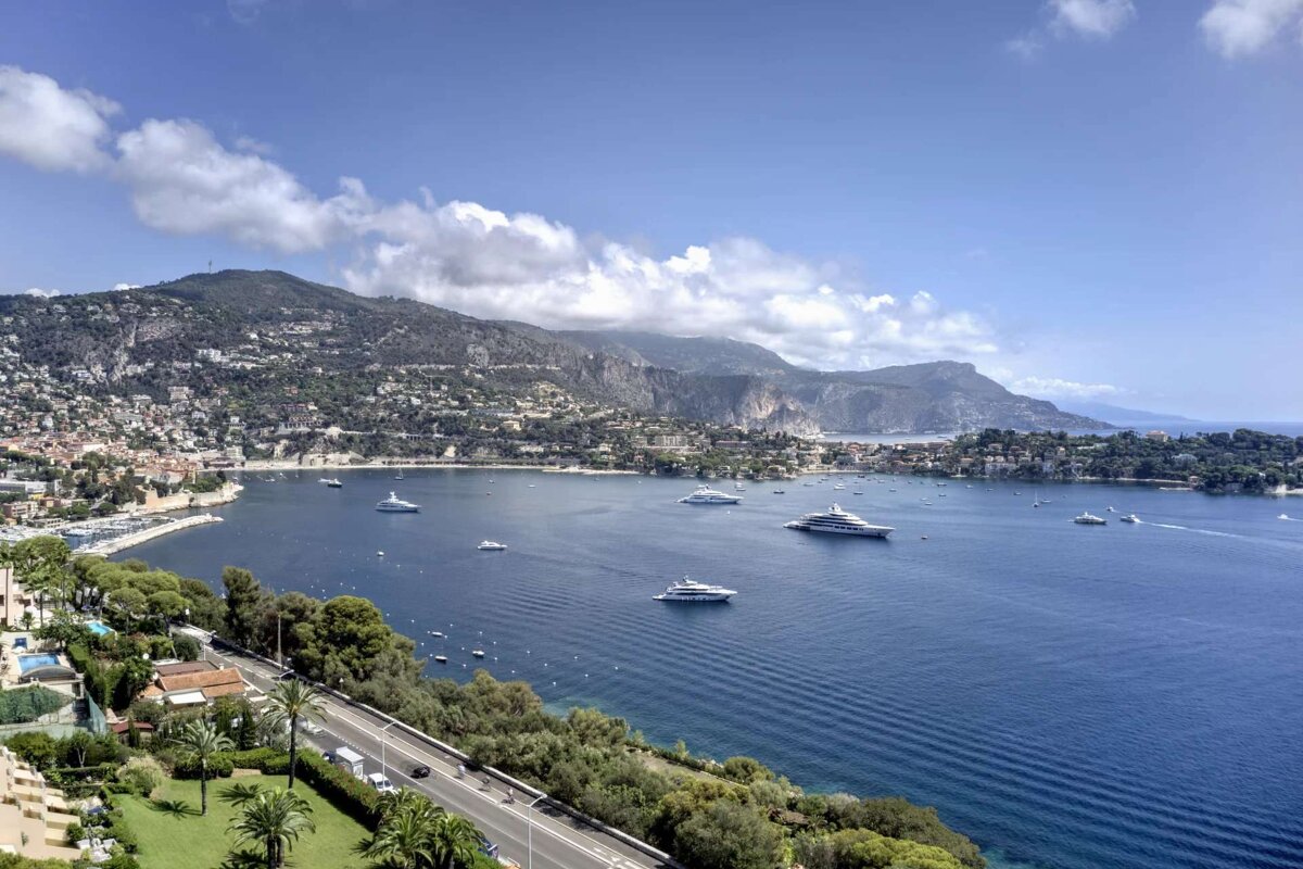 A large body of water with boats and mountains in the background