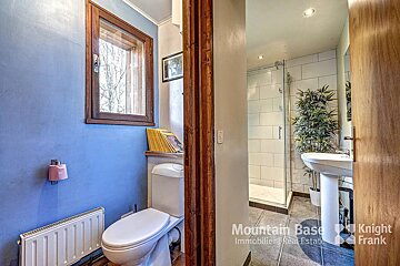 A bathroom with a toilet and a sink and a sign that says mountain base