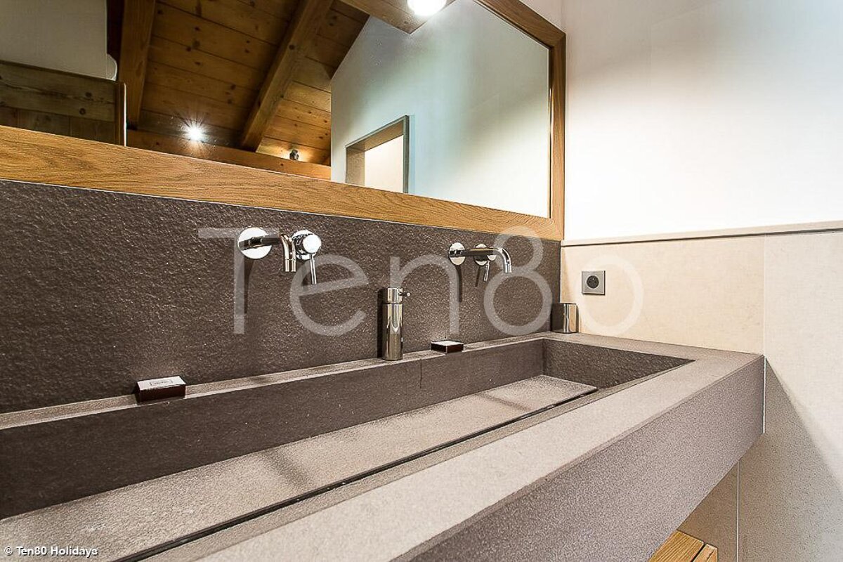 A bathroom with a sink and a mirror with the word ten8 on the wall