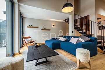 A living room with a blue couch and the word ten8d on the wall