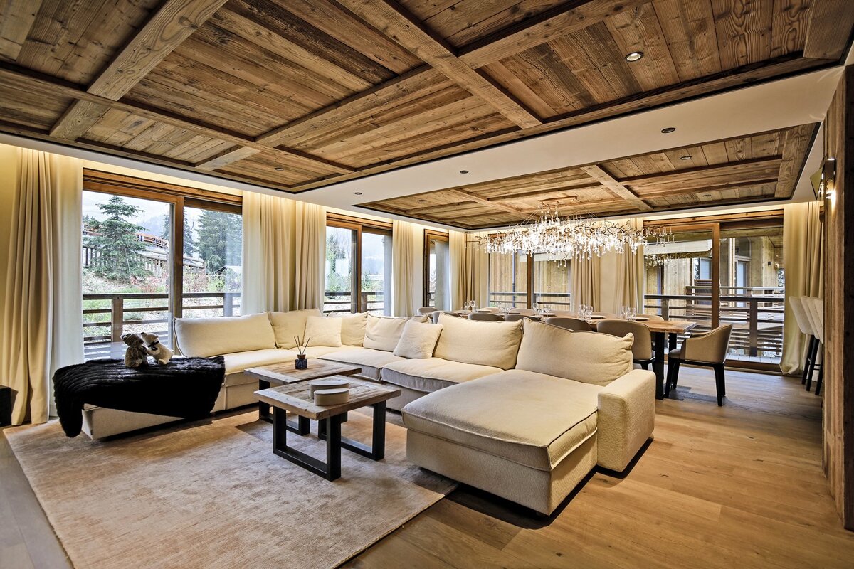 A living room with a sectional couch and a chandelier