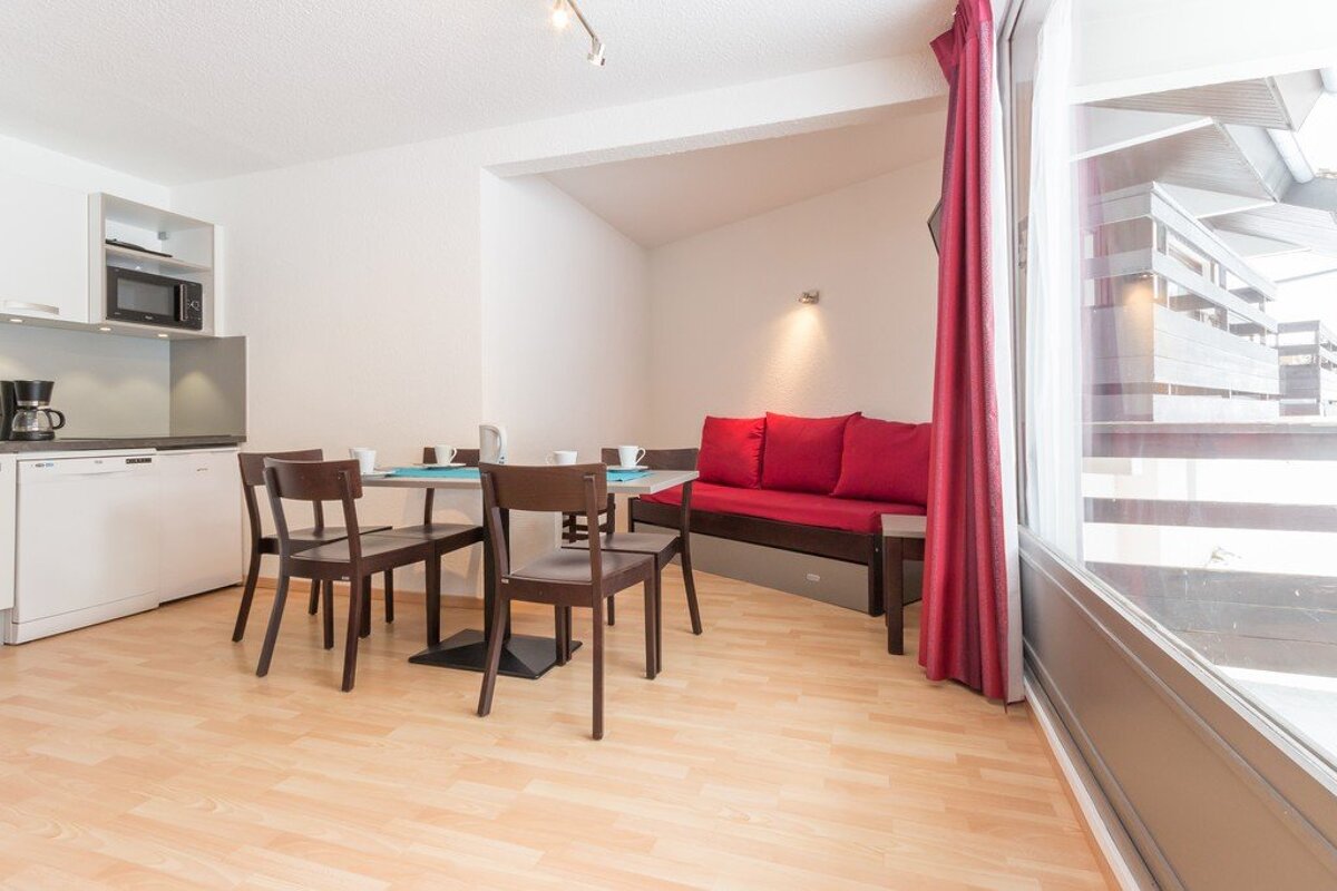 A kitchen with a table and chairs and a coffee maker