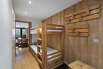 A bunk bed in a room with wood paneling