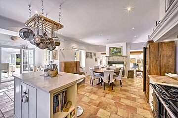 A kitchen with pots and pans hanging from the ceiling