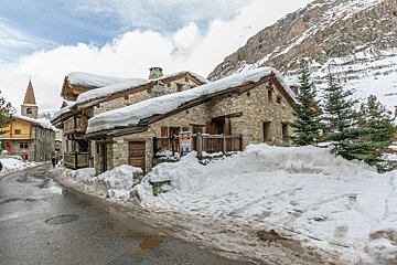 A snowy building with a sign that says ' alquiler ' on it