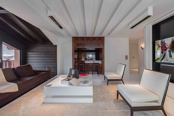 A living room with a couch and chairs and a television with a skier on it