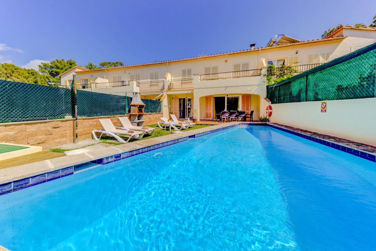 A swimming pool in front of a house with a no diving sign