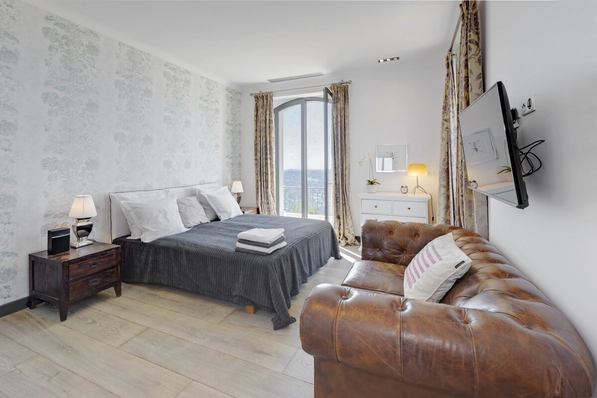 A bedroom with a large bed and a couch