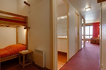 A bedroom with a bunk bed and a red carpet