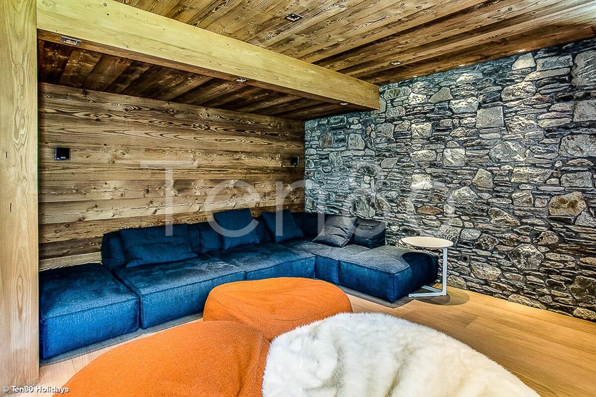A photo of a living room with a stone wall and a blue couch