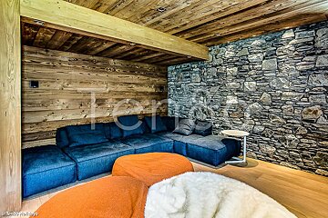 A photo of a living room with a stone wall and a blue couch