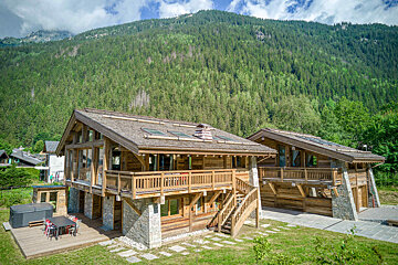 A large wooden house with a staircase leading up to the second floor