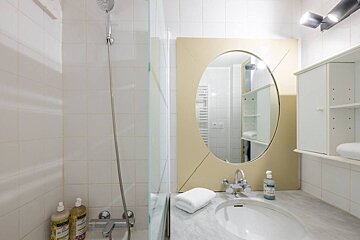 A bathroom with a sink a shower and a mirror