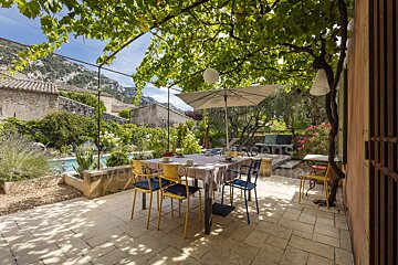 A patio with a table and chairs under an umbrella and a sign that says ' provence ' on it