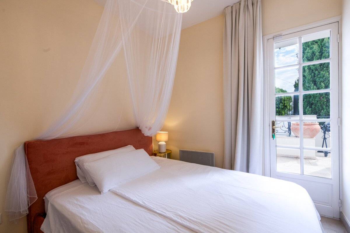 A bedroom with a canopy bed and a window