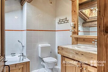 A bathroom with a toilet a sink and a mirror from mountain base immobiliers real estate