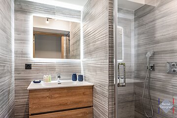 A bathroom with a rental designer logo in the corner