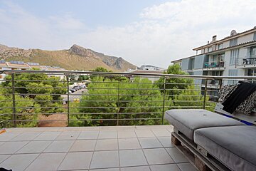 A balcony with a view of mountains and trees