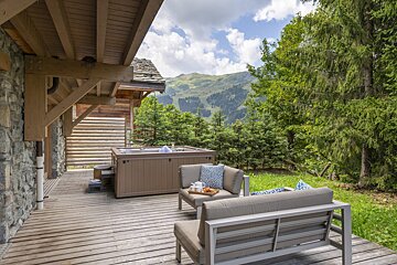 A wooden deck with a hot tub and a couch