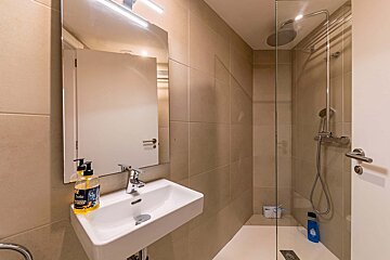 A bathroom with a sink a mirror and a shower