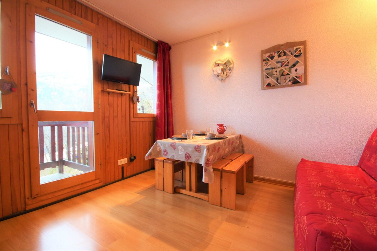 A living room with a table and a red couch