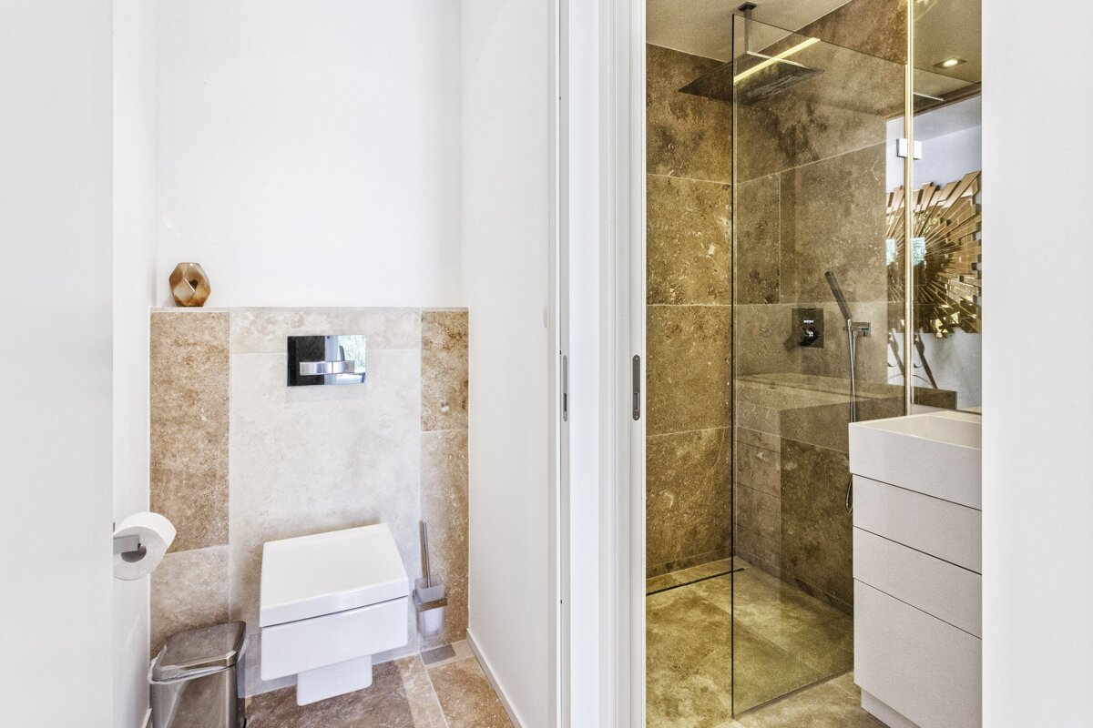 A bathroom with a toilet and a walk in shower