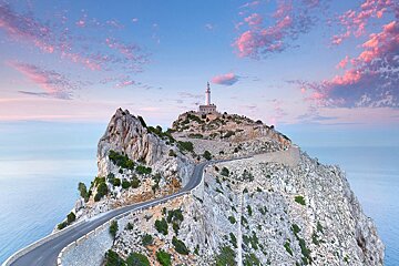 A road going to a lighthouse on top of a mountain