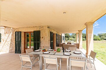 A patio with a table and chairs and a watermelon on it