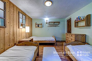 A bedroom with two beds and a dresser from mountain base